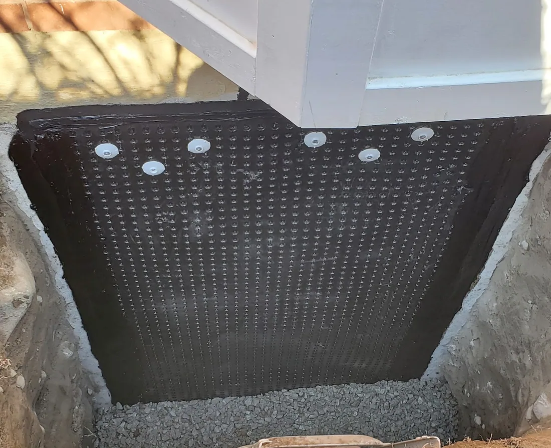 Basement waterproofing membrane applied to a foundation wall